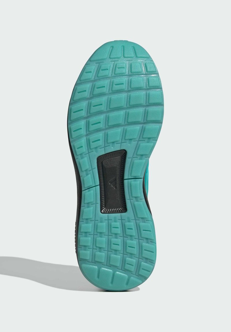 Schuhsohle mit einer strukturierten, türkisfarbenen Gummifläche, die ein quadratisches Muster und einen schwarzen Akzent in der Mitte aufweist.