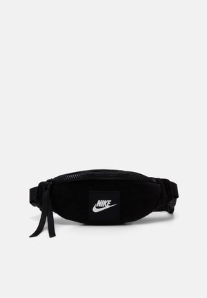 Sac banane noir Nike avec fermeture éclair, sangle réglable et logo Nike blanc à l'avant.