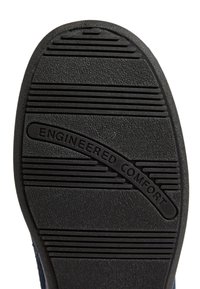 Svart gummisul med texturerad yta, med horisontella spår och texten "ENGINEERED COMFORT" präglad i en böjd design.