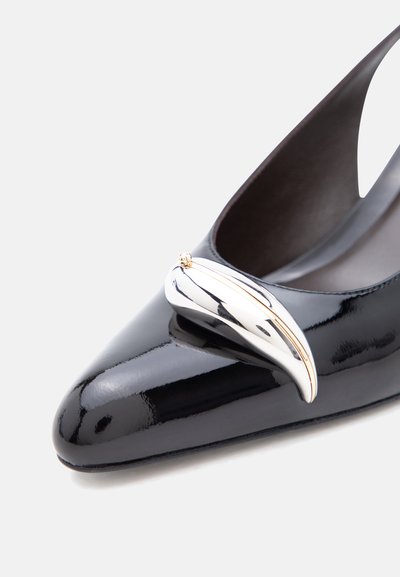 Μαύρο παπούτσι από πατεντ δέρμα με μυτερή μύτη και λαμπερό ασημί και χρυσό καμπυλωτό διακοσμητικό κούμπωμα στο μπροστινό μέρος.