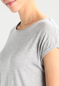 Grey short-sleeve t-shirt with a wide neckline, made of soft fabric, featuring rolled cuffs and a relaxed fit design.