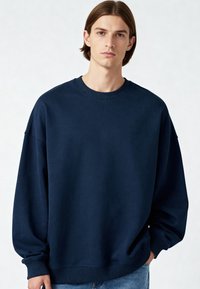 Tamsiai mėlynas per didelis džemperis su apykakle, raštuotomis rankovėmis ir apačia. Minkšta medžiaga su lygiu paviršiumi ir nuleistais pečiais.