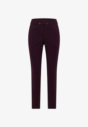 Fioletowe spodnie dresowe z miękkiego materiału, z elastycznym paskiem w talii, zwężanymi nogawkami i delikatnym połyskiem. Brak widocznych kieszeni lub wzorów.