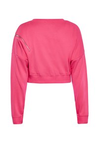 Ružový skrátený sweatshirt s dlhými rukávmi, okrúhlym výstrihom a zipsovou vreckom na ľavom ramene. Hladká textúra a elastické manžety.
