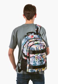 Drukowany plecak z kolorowymi wzorami komiksowymi, czarnymi akcentami, wieloma przegródkami, regulowanymi paskami i mocnym uchwytem na górze.