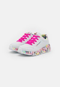 Skechers sneakers med en overdel i hvidt mesh, lyserøde snørebånd og en farverig sål med mønstre, der præsenterer abstrakte former og teksturer.