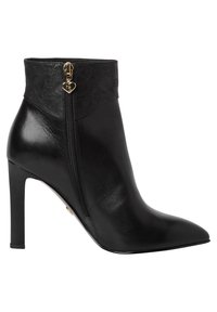 Stivaletto alla caviglia in pelle nera con punta a punta, tacco a stiletto alto e cerniera decorativa alla caviglia, con una fascia nera testurizzata.