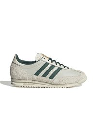Baskets Adidas avec un mélange de cuir lisse gris clair et de suède beige texturé, accentuées de rayures vert foncé et d'une semelle en caoutchouc.