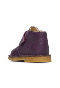 Scarpa alla caviglia per bambini in pelle viola con interno imbottito beige e suola in crepe, mostrata dal lato sinistro posteriore.