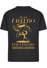 Schwarzes Baumwoll-T-Shirt mit einem verspielten, goldenen Grafik eines laufenden Kaffeebechers und dem Text "Mehr Espresso, weniger Depresso."