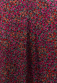 Tessuto scuro con un vivace motivo floreale in rosa, rosso e arancione, con piccoli accenti bianchi. Superficie texturizzata, materiale leggero.
