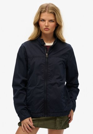 Navy blue lightweight jacket featuring a zip-up front, high collar, and two side pockets. Smooth texture with minimal detailing.