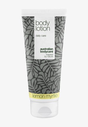 Bodylotiontub med grått bladmönster, gul accent, vitt lock och etiketter med texten "daily care" och "lemon myrtle".