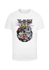Biela bavlnená tričko s farebnou grafikou postáv z "Yu-Gi-Oh! GX" s tučným písmom a kruhovým dizajnom.