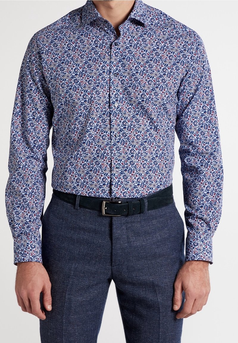 Herrskjorta med lång ärm i ett blommönster med blått, rött och vitt, knäppning med krage och kombinerad med mörkblå strukturerade byxor och ett svart skärp.