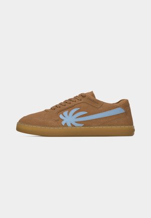 Brown suede sneaker with gum sole, blue abstract emblem on side, and matching brown laces.