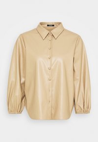 Beige konstläder skjorta med knappstängning i fronten, spetsig krage och voluminösa ärmar som är samlade vid muddarna. Slät, glansig textur.