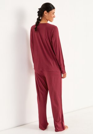 Bordeaux loungewear-set som består av en långärmad topp och löst sittande byxor, tillverkad av mjukt tyg med en slät yta. Enkel design och avslappnad passform.