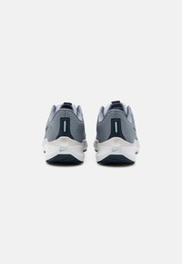 Scarpe da atletica grigie e blu navy con una tomaia in rete testurizzata, suola imbottita e un logo teal a contrasto sul tallone e sugli accenti laterali.