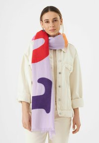 Écharpe colorée présentant un motif abstrait violet, rouge et orange sur un fond lavande clair ; fabriquée en matériau tissé doux.