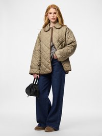 Πουπουλένο μπεζ μπουφάν με μεγάλο γιακά και καφέ διακοσμητική λεπτομέρεια, σε συνδυασμό με μπλε τζιν παντελόνι φαρδύ και μικρή μαύρη τσάντα χειρός. Λείο ύφασμα.