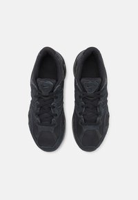 Svarta träningssneakers med mesh- och mockamaterial, med en texturerad ovandel, rund tå och snörningsdesign. Diskret logodetalj närvarande.