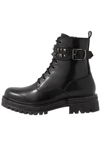 Czarne skórzane buty wojskowe z metalowymi ćwiekami i detalem paska, z okrągłym noskiem, sznurowanym przodem i chropowatą podeszwą. Płaski obcas.