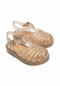 Sandali dorati scintillanti con un design a strappo, dotati di una chiusura a fibbia e di una suola spessa e luccicante. Materiale trasparente con una leggera lucentezza.