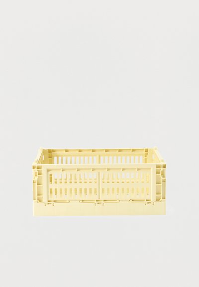 Caisse rectangulaire en plastique jaune pâle avec côtés et fond à lattes ouvertes, conçue pour le stockage ou le transport de marchandises.