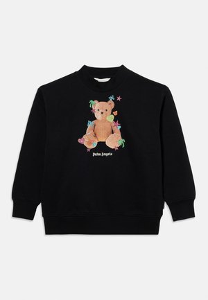 Musta pitkähihainen svetari, jossa on nallekarhu, jota ympäröivät värikkäät tähdet, sydämet ja palmut sekä alla teksti "Palm Angels".