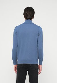 Blauwe gebreide trui met een hoge kraag, lange mouwen, geribde manchetten en zoom, met een gladde textuur en een getailleerd ontwerp.