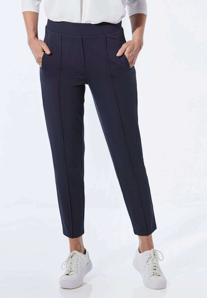 Navy, taillierte Hose mit hohem Bund, seitlichen Taschen und vorderen Falten. Hergestellt aus glattem Stoff mit einem schmal zulaufenden Beindesign.