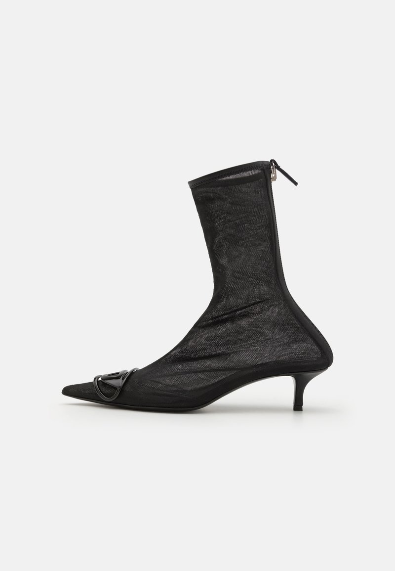 Black mesh ankle boot with a pointed toe, zip closure, and a small heel. Features a decorative buckle accent near the toe area.