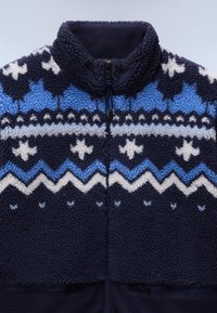 Giacca in fleece blu navy con colletto alto, impreziosita da motivi geometrici in azzurro chiaro e bianco, chiusura con zip frontale e doppie tasche laterali.