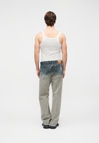 Ανδρικό τζιν σε γκρι χρώμα με ξεβαμμένο μπλε πίσω μέρος, ίσια γραμμή, σχέδιο με πέντε τσέπες και καφέ δερμάτινο ταμπελάκι στη μέση.