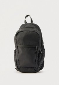 Sac à dos noir avec plusieurs compartiments zippés et une poignée supérieure, debout sur un fond clair uni.