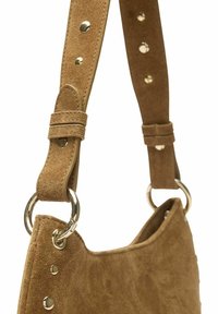Tan suedine handtas met een ronde vorm. Voorzien van een afneembare riem met metalen hardware en decoratieve studs op de riem en de zijkant van de tas.