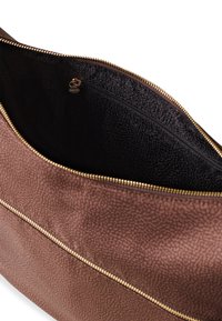 Braune strukturierte Handtasche mit einem goldenen Reißverschluss und einem schwarzen Innenraum. Verfügt über ein Reißverschlussfach innen für sichere Aufbewahrung.