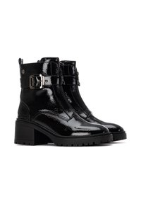 Botas de tobillo de charol negro con tacón grueso, detalles de hebilla y un acabado texturizado. Presenta cremallera frontal y suela de goma resistente.