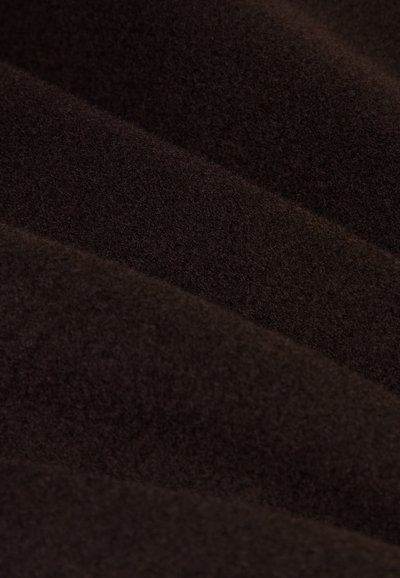 Donkerbruin fabric met een gestructureerd oppervlak, gekenmerkt door zachte, donzige vezels die in zachte golven zijn gerangschikt. Ideaal voor verschillende textieltoepassingen.