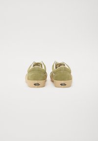 Groene suède sneakers met een laag profiel, voorzien van een crèmekleurige rand en een lichtgewicht beige rubberen zool. Logo zichtbaar op de hiel.