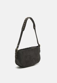 Zwarte denim handtas met een gebogen vorm, voorzien van een getextureerd oppervlak, gouden metalen accenten en een schouderband met decoratieve studs.
