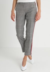 Pantalons gris à carreaux avec une coupe slim, dotés d'une bande latérale rouge. Fabriqués dans un tissu léger, avec une texture lisse et un design ajusté.