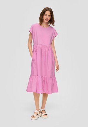 Rosa Baumwoll-Midikleid mit kurzen Ärmeln, einem geschichteten Rüschensaum und Taschen an beiden Seiten. Tragen mit hellen Plateausandalen.