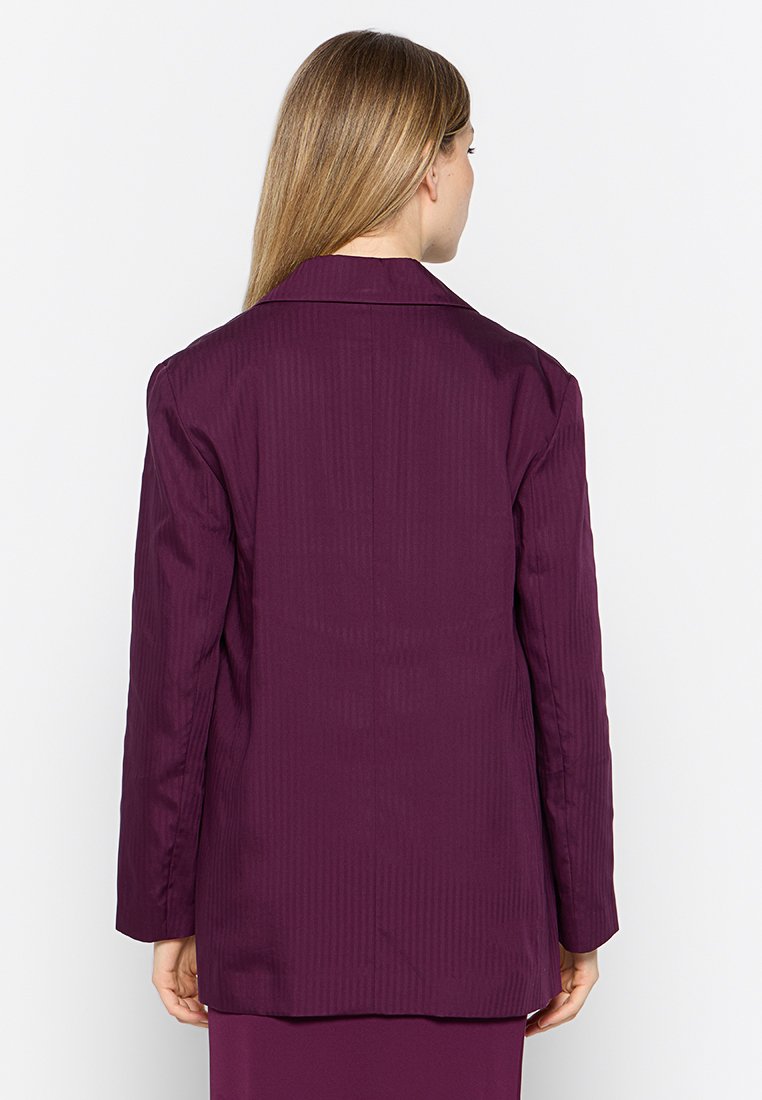 Blazer rayé violet avec un col cranté, des manches longues et une coupe droite. Texture de tissu lisse ; aucun fermoir ni poche visible.