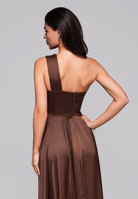 Braunes Satinkleid mit asymmetrischem One-Shoulder-Design, figurbetontem Oberteil, fließendem Rock und Reißverschluss an der Rückseite. Glatte Textur und elegante Silhouette.