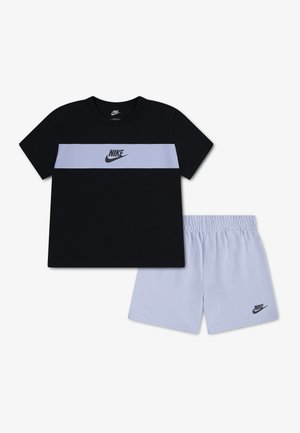 T-shirt Nike noir à manches courtes avec une bande horizontale lavande et un short lavande assorti, tous deux ornés de logos Nike.