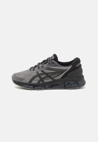 Sport shoes in gray mesh material with black accents. Rounded toe, cushioned sole, and thick black rubber outsole. Laced closure system.