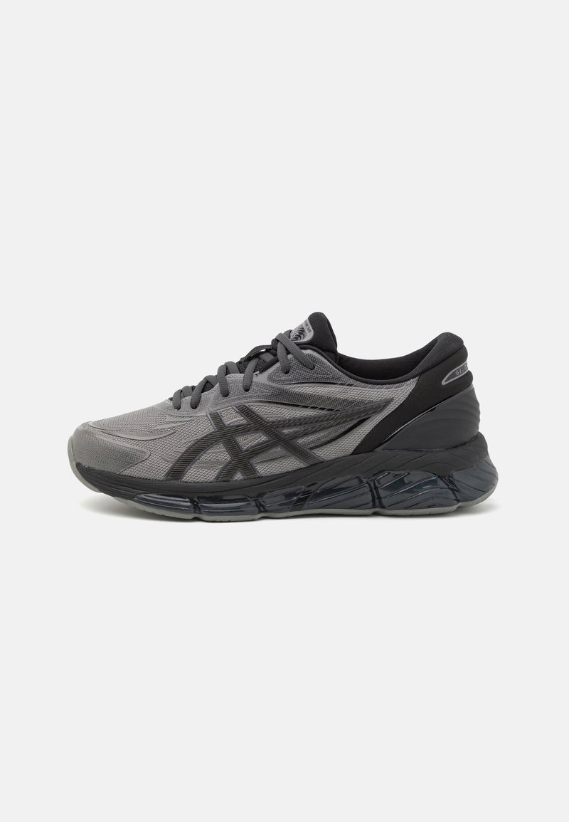Sport shoes in gray mesh material with black accents. Rounded toe, cushioned sole, and thick black rubber outsole. Laced closure system.