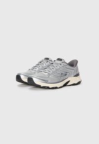 Pair of silver and gray athletic sneakers with black soles and white midsoles, positioned side by side on a white background.